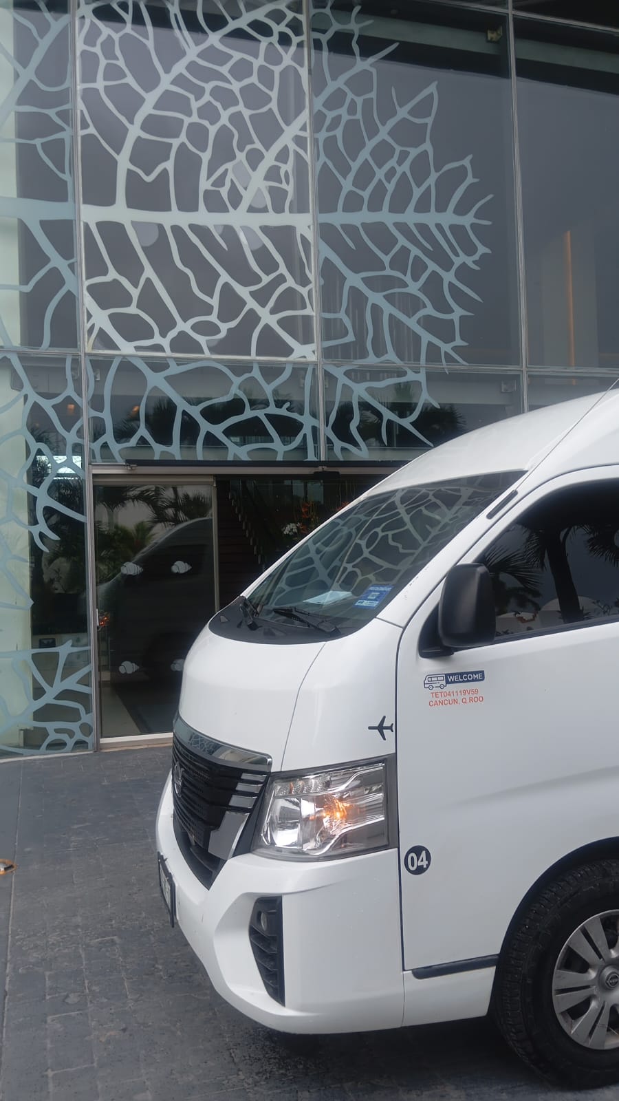 Chofer recogiendo pasajeros en la entrada de un hotel en Cancún